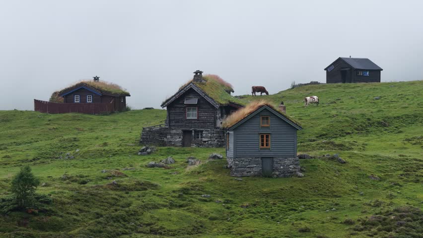 A drone footage of the traditional houses in Skjerdingsdalssaetre small rural town nestled on the green cliffs of Videseter, Norway