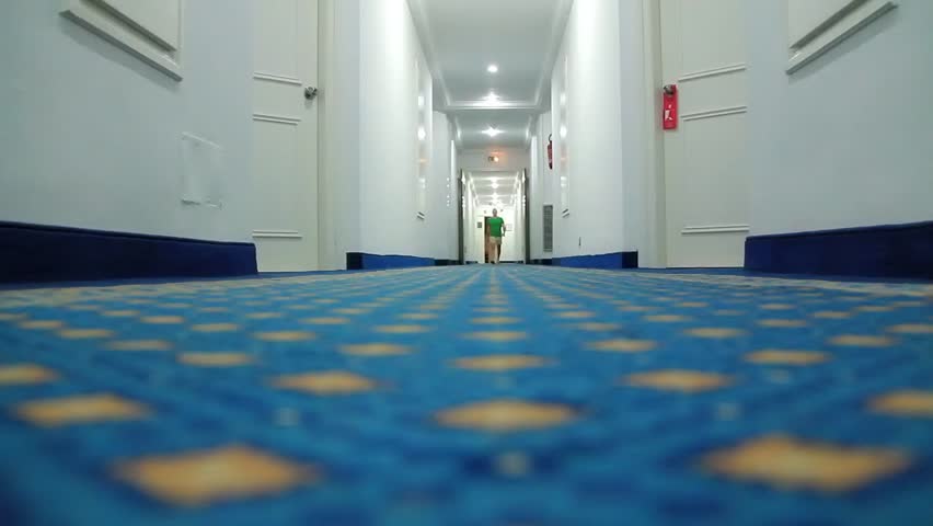 Man walking down a hotel corridor
