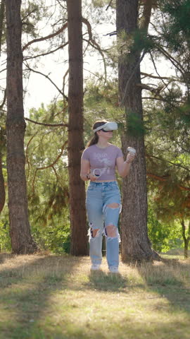 Vertical shot of woman walking through green field with VR virtual headset on.