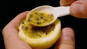Hands Holding Yellow Passion Fruit While Scooping Pulp with White Spoon in Slow Motion from Close Up Angle, Tropical Freshness Concept. - Powered by Shutterstock - Get 15% off with code: PIKWIZARD15
