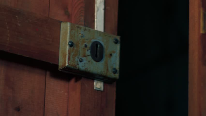 Creepy old wooden door opens and closes in wind close up zoom shot selective focus