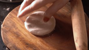Close-up of a woman hand making Indian roti or chapati at home. Traditional flatbread preparation at kitchen - Powered by Shutterstock - Get 15% off with code: PIKWIZARD15