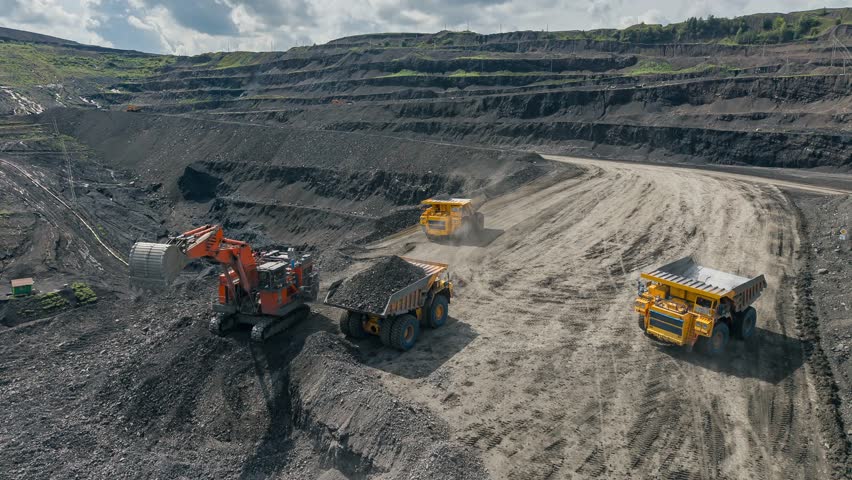 Aerial Timelapse mining industry, open pit mine with industrial machinery excavator loads coal into large quarry truck.
