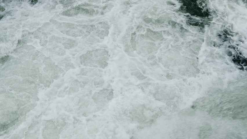 rapid flow of water plunges down in waterfall, top view, slow motion
