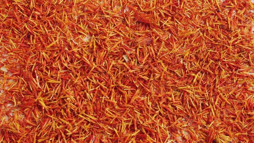 Dried crimson saffron on grey desk close-up macro. Orange red spice for food. Crocus sativus flower saffron