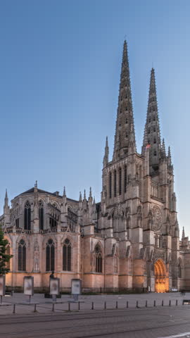 Cathedrale Saint-Andre de Bordeaux day to night transition timelapse hyperlapse with twin spires after sunset. Illuminated buildings on the square create a serene urban atmosphere. Bordeaux, France