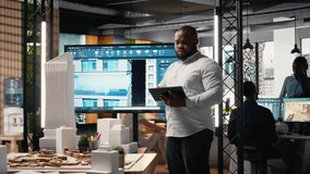 African american real estate developer reviews city planning layout on laptop, setting infrastructure goals while preparing a presentation on sustainable housing urban development. Camera A. - Powered by Shutterstock - Get 15% off with code: PIKWIZARD15