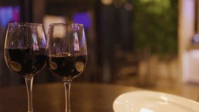 Two people clink red wine glasses at a warmly lit hotel bar. - Powered by Shutterstock - Get 15% off with code: PIKWIZARD15