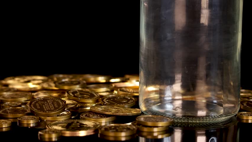 Gold cryptocurrency tokens fall into a clear jar, surrounded by coins, under dramatic studio lighting - Powered by Shutterstock - Get 15% off with code: PIKWIZARD15