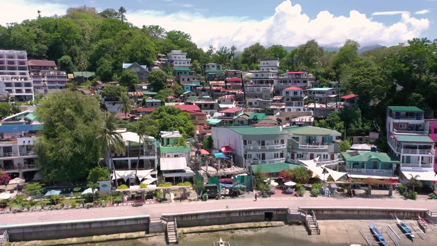 A stunning drone video captures Puerto Galera and Sabang Bay with tcliff houses, boats, and diving schools, showcasing the tropical beauty of this famous Philippine destination.