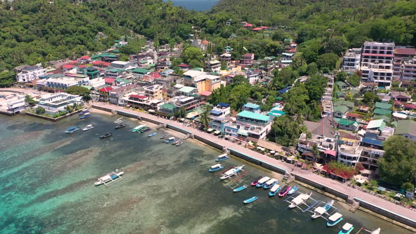 Stunning drone video captures Puerto Galera and Sabang with turquoise waters, boats, and diving schools, showcasing the tropical beauty of this famous Philippine destination.