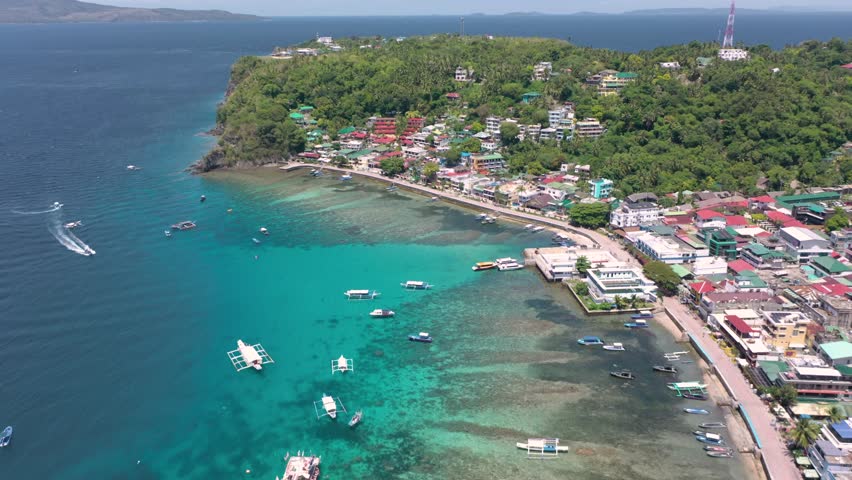 A stunning drone video captures Puerto Galera and Sabang with turquoise waters, boats, and diving schools, showcasing the tropical beauty of this famous Philippine destination.