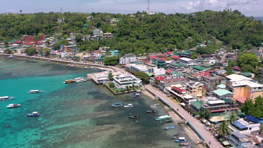 A stunning drone video captures Puerto Galera and Sabang Bay with turquoise waters, boats, and diving schools, showcasing the tropical beauty of this famous Philippine destination.
