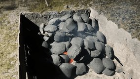 Coals in the grill begin to ignite and smolder, with light smoke rising. Atmospheric shot for barbecue, picnic, and cooking projects. - Powered by Shutterstock - Get 15% off with code: PIKWIZARD15