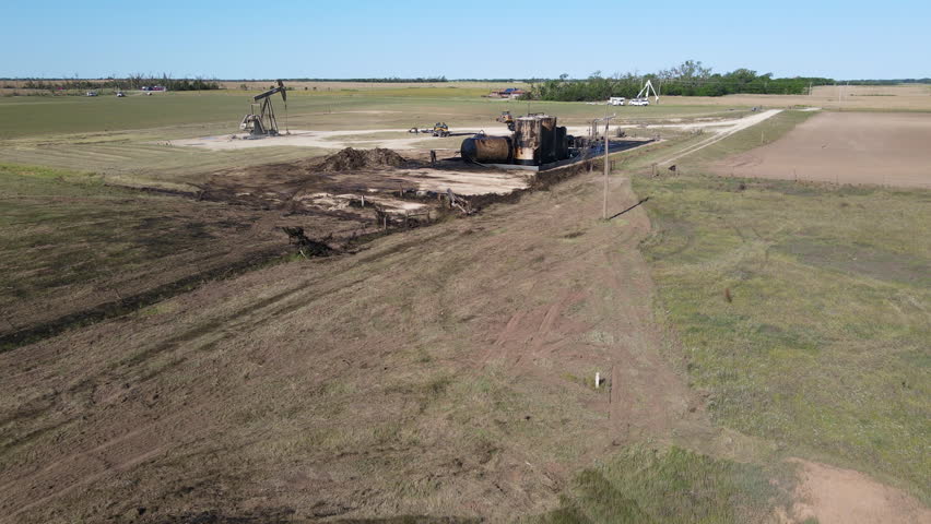Aerial view backwards over spilled oil and tanks, Tornado destruction in USA