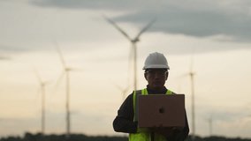 Engineer working on laptop in wind farm with turbines in background. Concept of renewable energy monitoring, smart grid analysis, and clean power field inspection. - Powered by Shutterstock - Get 15% off with code: PIKWIZARD15