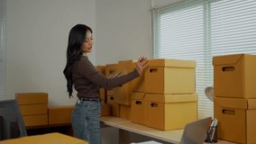 Young female manager conducting inventory management, navigating digital tablet while verifying cardboard shipping packages within storeroom storage workspace - Powered by Shutterstock - Get 15% off with code: PIKWIZARD15