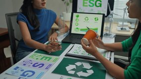 Professionals discussing environmental, social, and governance - esg - criteria and demonstrating commitment to sustainability with a recyclable cup - Powered by Shutterstock - Get 15% off with code: PIKWIZARD15