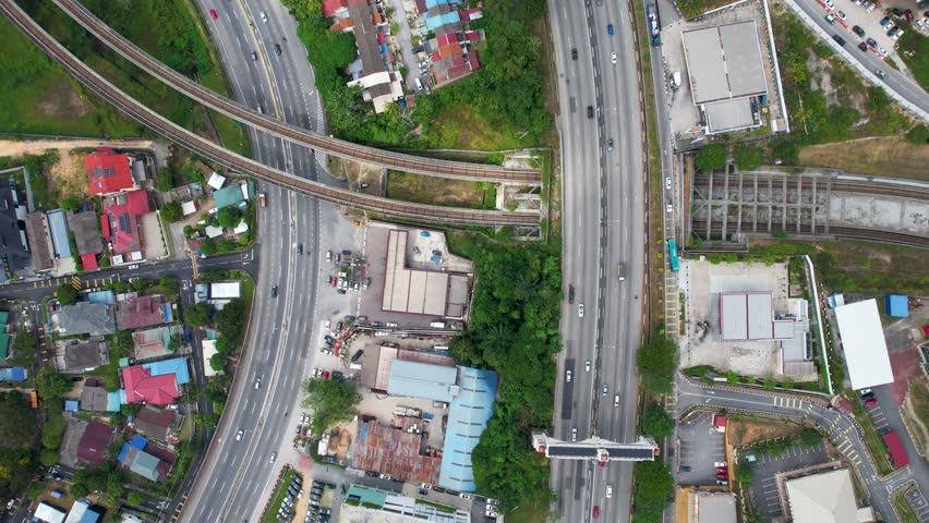 Top-down Aerial landscape drone view of Sri Petaling curving highway roads and traffic blended with housing estates in the city of Kuala Lumpur, Malaysia bird