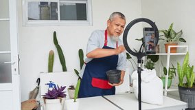 Gardener greets viewers during live stream while giving tutorial filling pots with soil - Powered by Shutterstock - Get 15% off with code: PIKWIZARD15