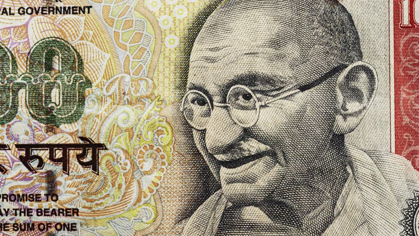 Close pan across Indian rupee banknote portrait with Devanagari and English text