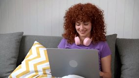 Redhead woman using laptop while sitting on comfortable sofa at home - Powered by Shutterstock - Get 15% off with code: PIKWIZARD15