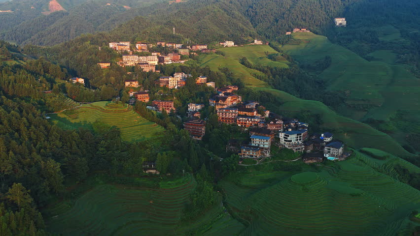 Aerial shot of the spectacular Longji Terraced Fields with traditional village at sunset in Guilin, Guangxi Province, China.