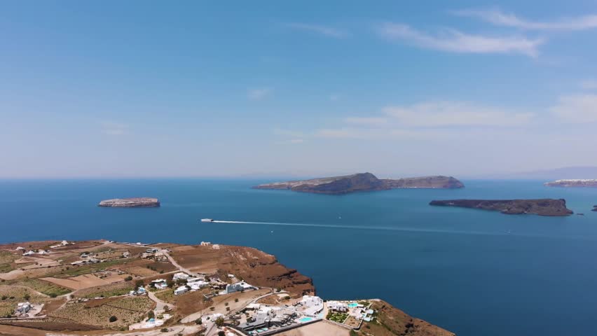 Aerial footage showcasing the panoramic view of the Santorini caldera, the deep blue Aegean Sea, and the volcanic islands