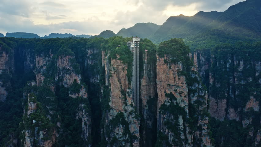 Unique outdoor glass elevator built on a sheer cliff among spectacular quartz-sandstone pillars in Hunan. majestic Zhangjiajie national forest park, Wulingyuan Scenic Area in China. 