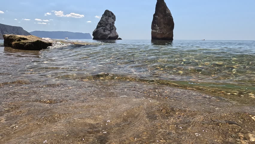 Sea beach waves, gentle water washing sandy shore with iconic rock formations