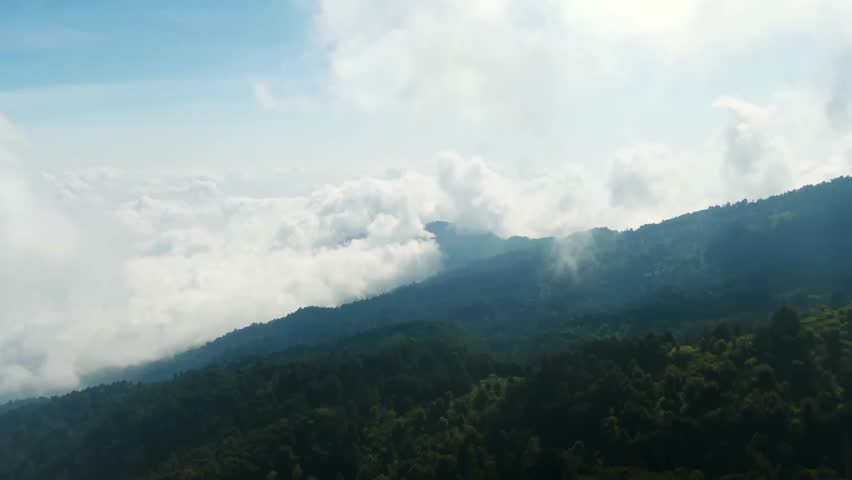 Drone view of Nevado de Colima’s forested slopes covered in mist and drifting clouds, México