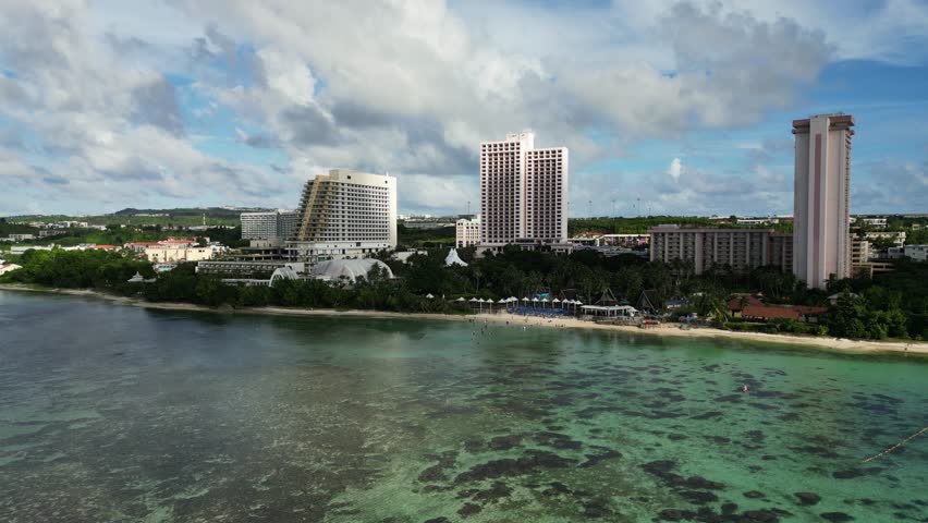 Beachfront Hotels By Tumon Bay With Crystal Clear Water In Guam. - aerial shot