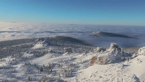 Aerial view drifts over the Sheregesh ridge as a vast cloud inversion fills the valley. Crisp winter light reveals orange cliff and glittering snow, inviting travel and ski adventure - Powered by Shutterstock - Get 15% off with code: PIKWIZARD15
