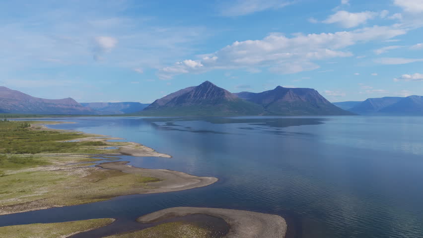 Midday clarity over Lake Lama with a mountain massif above mirror water on the Putorana Plateau. Sharp ridges, calm surface and broad shoreline convey wilderness and premium travel scenery in Siberia