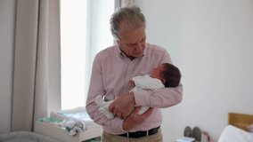 Grandfather holding his newborn grandchild in a brightly lit room, smiling down at the baby, emphasizing love, joy, and the precious bond of family - Powered by Shutterstock - Get 15% off with code: PIKWIZARD15