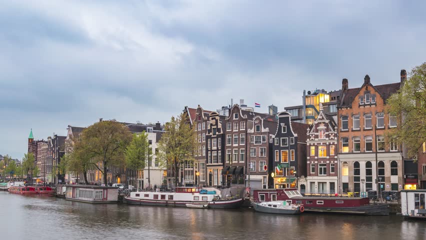 Amsterdam Netherlands time lapse day to night city skyline at canal waterfront