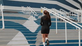 Female athlete in black attire runs up stadium stairs, highlighting her commitment to fitness and strength training - Powered by Shutterstock - Get 15% off with code: PIKWIZARD15