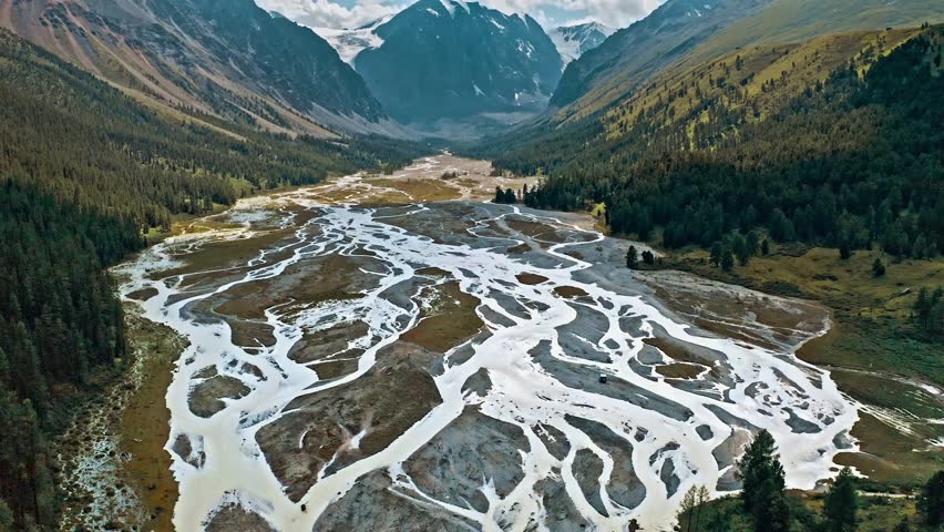 Aerial View Glacial River Valley Mountain Landscape Nature Scenery Arid Terrain Braided River Channels Water Flow Alpine Ecosystem Remote Wilderness Area High Altitude Confluence Glacier Meltwater