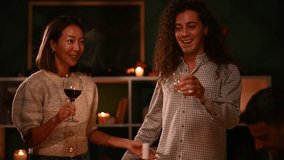 Multicultural friends raising wine glasses during warm thanksgiving gathering, celebrating togetherness with joyful smiles and festive spirit in cozy home setting - Powered by Shutterstock - Get 15% off with code: PIKWIZARD15