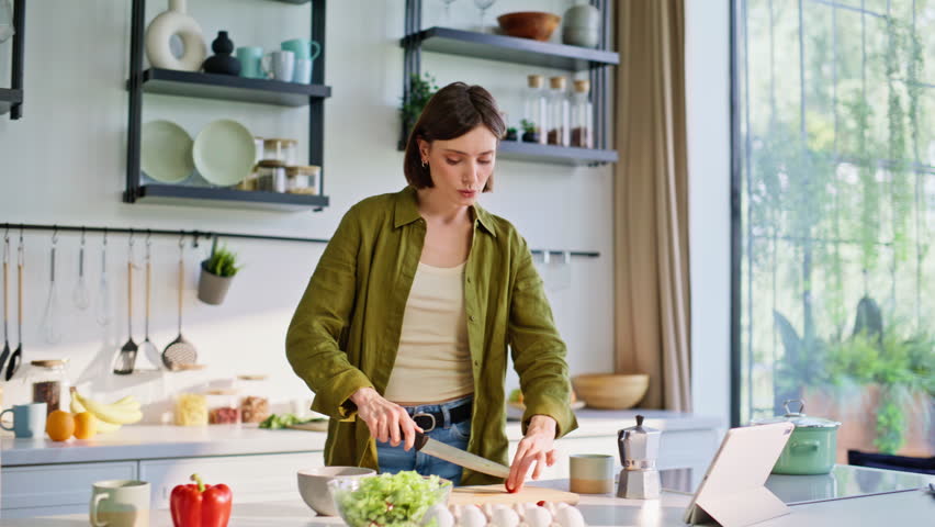 Dancing brunette preparing healthy meal moving body along favorite song at cozy kitchen closeup. Carefree joyful woman listening music cooking breakfast. Smiling lady making tasty vegan bowl alone 