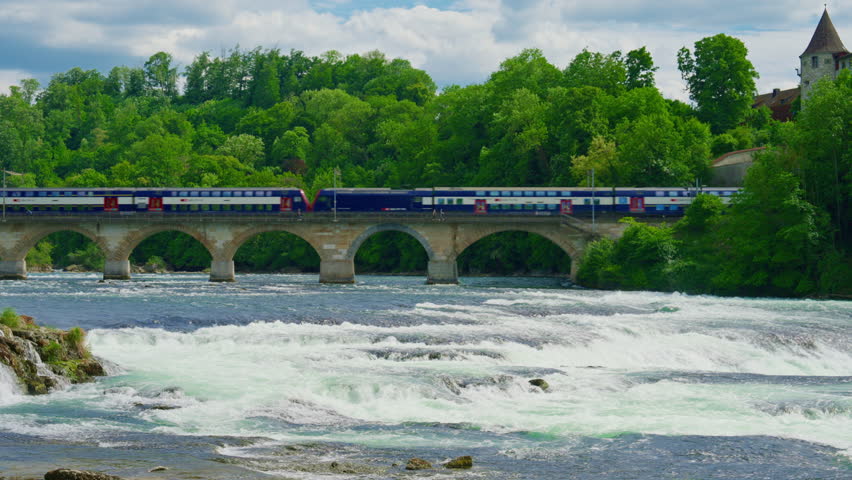Switzerland Rhine Falls waterfall. Largest natural river waterfall Europe. Tourists sail by boat directly to the waterfall to feel the spray on themselves. Train