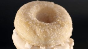 Vertical camera pan reveals stacked donuts with chocolate, pink and white glaze on dark background to emphasize colorful dessert variety in product layout - Powered by Shutterstock - Get 15% off with code: PIKWIZARD15