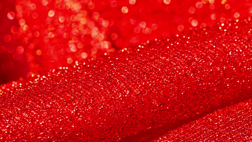 Christmas and New Year background.Red glitter macro background with shining bokeh .iridescent gradient texture.Folds of shiny fabric in red tones. 4k footage