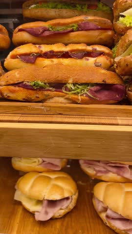 Fast food. Sandwiches and snacks displayed on a store counter showcase. Everyday consumer choice, vertical view