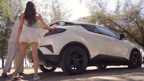 Happy Asian man and woman road trip travel the sea on summer beach holiday vacation. Group of People friends enjoy and fun outdoor lifestyle taking off picnic equipment from car trunk at the beach. - Powered by Shutterstock - Get 15% off with code: PIKWIZARD15