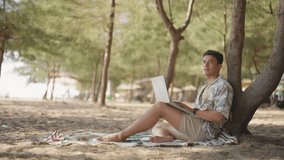 Asian man remote working corporate business on laptop computer while travel the sea on summer beach holiday vacation. Workation, work from anywhere with wireless technology and digital gadget device. - Powered by Shutterstock - Get 15% off with code: PIKWIZARD15