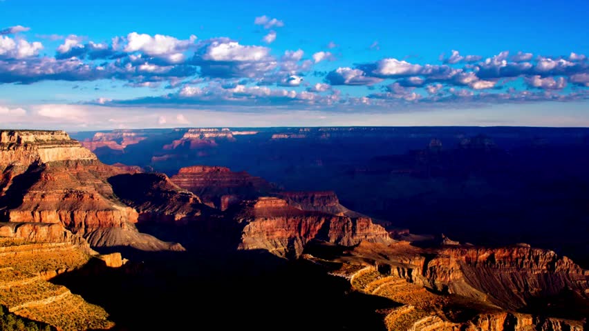 Time lapse of the Grand Canyon showing moving clouds and changing light across dramatic desert cliffs and valleys.