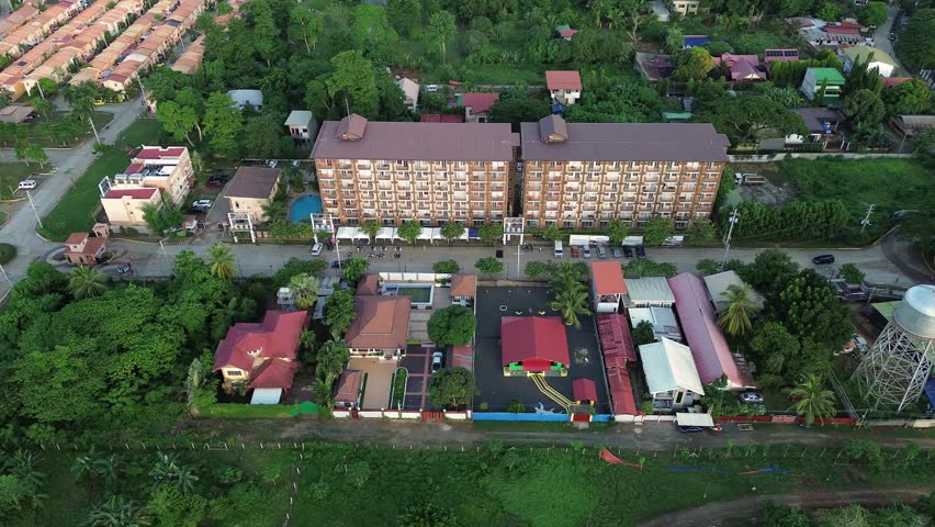 Aerial view of a luxury resort and nearby residential developments in Bancao-Bancao, Puerto Princesa, Palawan, Philippines urban planning in tropical greenery at golden hour