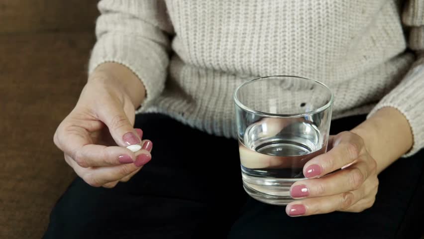 taking medicine painkiller pills on hand capsules health care medicare pharmacy and treatment concept close up