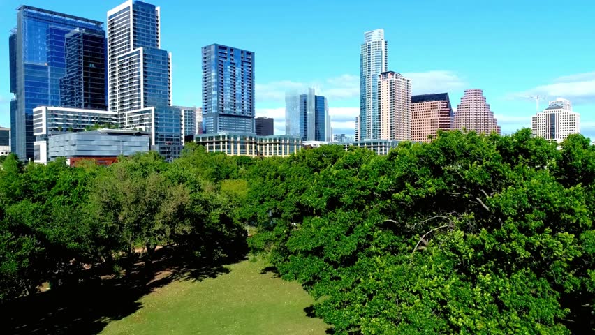 Downtown austin, texas, skyline with green trees in the foreground on a sunny day